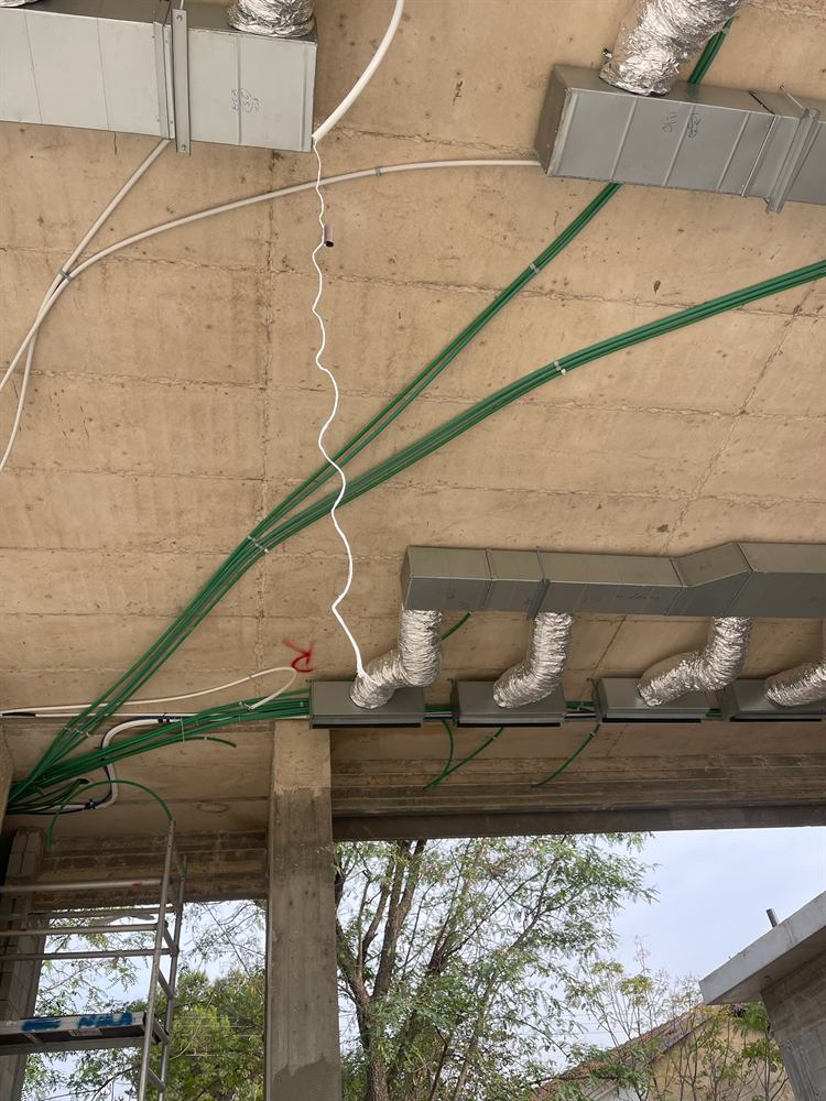 צנרת חשמל מקובעת לתקרת בטון באתר בנייה
